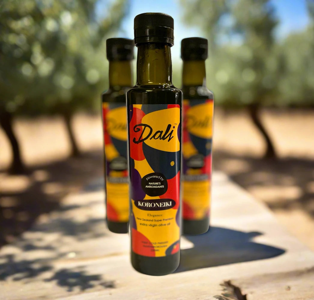 Bottle of Dali Koroneki olive oil with a colourful label on a blurred background