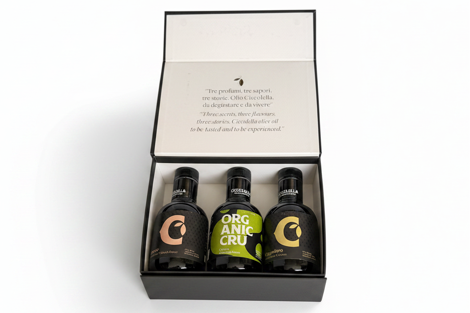 A gift set of three ciccollella olive oils presented in an open black box with a white insert card featuring printed text.