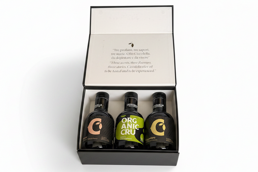 A gift set of three ciccollella olive oils presented in an open black box with a white insert card featuring printed text.